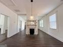 A rustic fireplace sits at the center of the living room, flanked by windows and doorways, with dark floors at 30 Poplar St, Porterdale, GA 30014