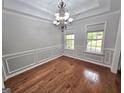 Dining room features hardwood floors, decorative molding, and a view of the green outdoors through dual windows at 64 Shadow Ct, Palmetto, GA 30268