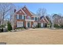 Beautiful brick home with green shutters, mature trees, and a well-manicured front yard at 319 Corrigan Trce, Peachtree City, GA 30269
