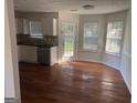 Bright kitchen featuring white cabinets, stainless steel appliances, hardwood floors, and a dining area with natural light at 435 Cedarhurst Rd, Lawrenceville, GA 30045
