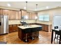 Modern kitchen with granite countertops, a kitchen island with seating and stainless steel appliances at 9108 Alden Dr, Locust Grove, GA 30248
