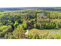 Beautiful aerial view of a well-maintained home by a lake surrounded by lush green trees at 226 Le Paradis Blvd, Sharpsburg, GA 30277