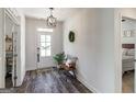 Bright foyer features hardwood floors, a decorative light fixture, and a welcoming bench, creating a warm ambiance at 7435 Ansley Park Way, Cumming, GA 30028