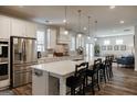 Modern kitchen boasts a large island with seating, stainless steel appliances, and hardwood floors at 7435 Ansley Park Way, Cumming, GA 30028