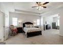 Spacious main bedroom with tray ceiling, neutral carpet, and ensuite bathroom access at 7435 Ansley Park Way, Cumming, GA 30028