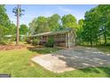 Well-kept single-story home featuring a nice yard and a wide driveway for easy parking and access at 1256 Horsley Mill Rd, Carrollton, GA 30116