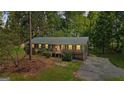 Attractive single-story house with a green metal roof, gray siding, and a lovely lawn with mature trees at 1256 Horsley Mill Rd, Carrollton, GA 30116