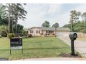 Exterior of a single-Gathering home featuring a well-manicured lawn and a Century 21 real estate sign at 15 Pine Run Rd, Carrollton, GA 30116