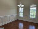 Spacious dining room with hardwood floors, wainscoting and a decorative chandelier at 30 Scouts Ridge Dr, Covington, GA 30016