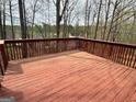 Spacious stained wooden deck, surrounded by trees, offering a private outdoor living space with natural views at 602 Springharbor Dr, Woodstock, GA 30188