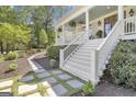 Side view of a beautiful home with white siding, complemented by stone pathways and manicured landscaping at 105 Suffolk Pl, Fayetteville, GA 30215