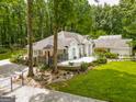 White home featuring a covered patio, landscaped yard and inviting outdoor space at 135 Adams Park Dr, Fayetteville, GA 30214