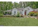Elegant white home with a red door and stone landscaping accents at 135 Adams Park Dr, Fayetteville, GA 30214