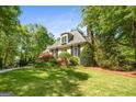 Beautiful home exterior featuring lush landscaping, dormer window, stone accents and inviting front yard at 204 Clear Springs Ln, Peachtree City, GA 30269