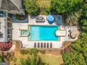 Aerial view of a backyard showcasing a large pool, adjacent jacuzzi, seating area, lounge chairs, and mature landscaping at 204 Clear Springs Ln, Peachtree City, GA 30269