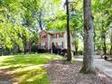 Charming two-story home with red shutters and a well-manicured lawn, surrounded by mature trees at 110 Cedar Creek Ct, Fayetteville, GA 30215