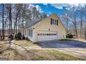 Spacious two-car garage with an attached side entry and lush tree coverage at 3341 Deer Hollow Sw Trl, Conyers, GA 30094