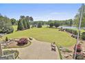 Expansive backyard features lush green lawn, patio with seating, and scenic view of the golf course and lake at 780 Birkdale Dr, Fayetteville, GA 30215