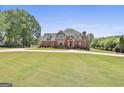 Attractive brick home with gabled roof and expansive front lawn offers classic charm and curb appeal at 780 Birkdale Dr, Fayetteville, GA 30215