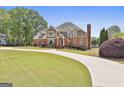 Stunning brick home with well-manicured lawn and a circular driveway offering beautiful curb appeal at 780 Birkdale Dr, Fayetteville, GA 30215