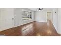 Bright living room featuring hardwood floors, fresh gray paint, a ceiling fan, and natural light from a large window at 1120 Starline Dr, Smyrna, GA 30080