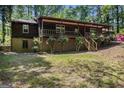 Rustic cabin-style home with charming front porch, brick foundation, and lush green lawn at 20 King Pl, Stockbridge, GA 30281