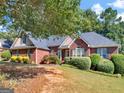 Beautiful red brick home with a well-manicured lawn, lush landscaping, and a welcoming entrance at 925 Champions Way, Mcdonough, GA 30252
