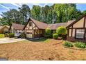 This home features Tudor-style architecture, a garage, and meticulously maintained landscaping at 335 Jeff Davis Pl, Fayetteville, GA 30214