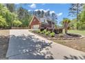 Long driveway leading to a beautiful red brick home with lush landscaping and mature trees at 65 Jacksons Vly, Sharpsburg, GA 30277