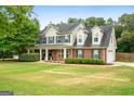 Charming two-story home featuring a welcoming front porch, brick accents, and a well-manicured lawn at 220 Calli Ct, Mcdonough, GA 30252