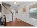 Bright foyer with hardwood floors, a staircase, and a view into the dining area at 220 Calli Ct, Mcdonough, GA 30252