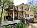 Inviting front porch with seating area of charming two-story home featuring a front porch, attached garage at 5363 Forest Dr, Loganville, GA 30052