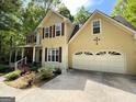 Close up of the house showing the garage, flower garden and a charming two-story home at 5363 Forest Dr, Loganville, GA 30052