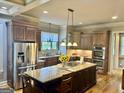 Spacious kitchen featuring custom cabinets, stainless appliances, and a center island with granite countertop at 100 Trotters Rdg, Fayetteville, GA 30215