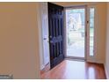 Bright entryway with wood floors, black front door, and sidelight window at 25 Pacific Ave, Sharpsburg, GA 30277