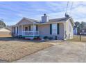 Single story home with front porch, green trim and drought resistant lawn at 70 Grove Creek Dr, Locust Grove, GA 30248