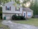 Charming split-level home featuring a brick facade, garage, and well-maintained front yard at 1975 Longwood Ct, Lithonia, GA 30058