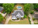 Overhead view of white two-story home, lush lawn, mature trees, in-ground pool and circular driveway at 608 Bellenden Dr, Peachtree City, GA 30269