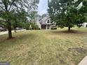Charming exterior of the home framed by mature trees and a spacious front yard at 441 Lilywood Dr, Mcdonough, GA 30253