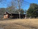 Ranch style home with a cozy front porch nestled in a grassy, spacious lot at 5780 Hill Rd, Powder Springs, GA 30127