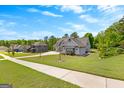 View of a well-manicured lawn and beautifully designed home nestled in a serene neighborhood at 266 Blue Point Pkwy, Fayetteville, GA 30215