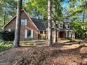 Traditional brick home with white shutters and mature trees surrounding the property at 110 The Farm Rd, Mcdonough, GA 30252