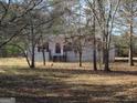 Charming single-story home with a wooded front yard and rustic details on a sunny day at 526 Mount Carmel Church Rd, Temple, GA 30179