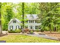 Charming two-story home with a manicured lawn and surrounded by lush greenery and mature trees at 120 Majesty Ln, Fayetteville, GA 30215