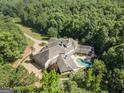 Aerial view of a private estate featuring a swimming pool and surrounding woodlands at 320 Riverbend Dr, Mcdonough, GA 30252