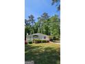 Charming home features a covered front porch, well-manicured lawn, mature trees, and convenient covered parking at 1973 Niskey Lake Sw Rd, Atlanta, GA 30331
