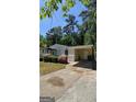 Home with covered parking, mature trees, and a quaint facade needing some love in an established community at 1973 Niskey Lake Sw Rd, Atlanta, GA 30331