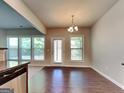 Bright dining room with wood floors, a modern chandelier, and access to the backyard at 3733 Upland Dr, Mcdonough, GA 30253