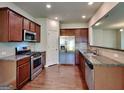 Modern kitchen featuring stainless steel appliances, granite countertops, and beautiful wood flooring at 3733 Upland Dr, Mcdonough, GA 30253