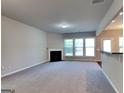 Spacious living room featuring plush carpet, a cozy fireplace, and large windows for natural light at 3733 Upland Dr, Mcdonough, GA 30253